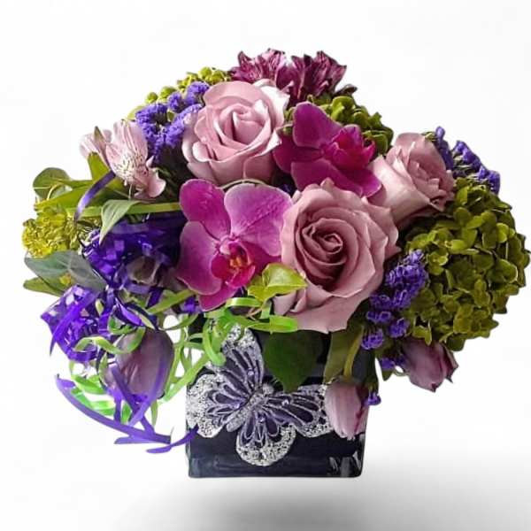 Pink roses and orchids in a black vase with purple ribbon