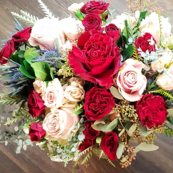 Bouquet of red and blush roses with mixed greenery