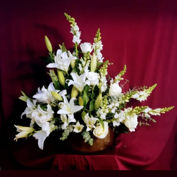 White lilies and roses arranged in a low vase