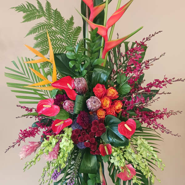 Tall tropical floral arrangement with orchids, anthuriums, and birds of paradise