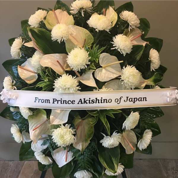 Large white floral standing spray with a ribbon reading From Prince Akishino of Japan
