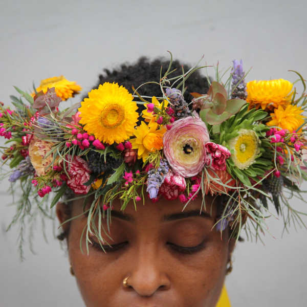 Person wearing a colorful flower crown with yellow and pink blooms