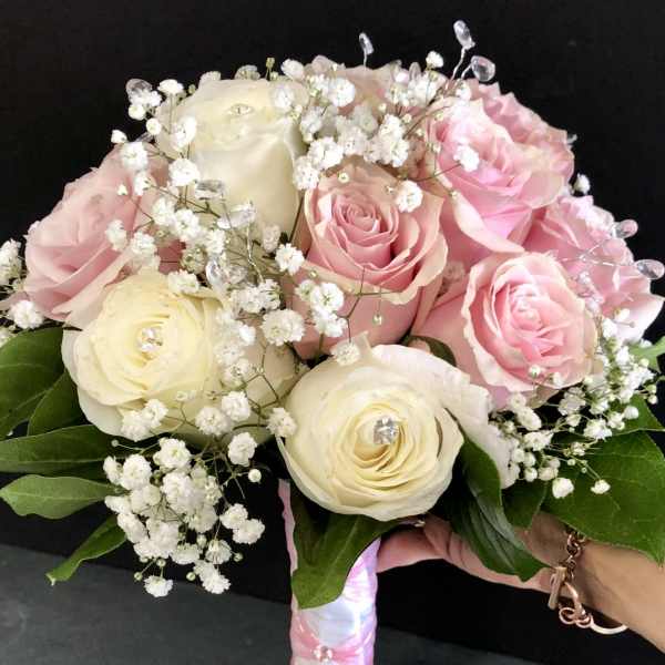 Pink and cream rose bouquet with baby's breath and a wrapped handle