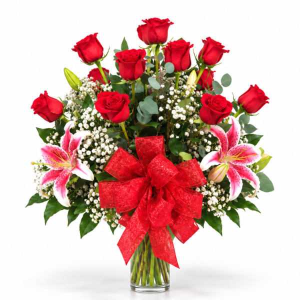 Red roses and pink lilies in a glass vase with a red bow