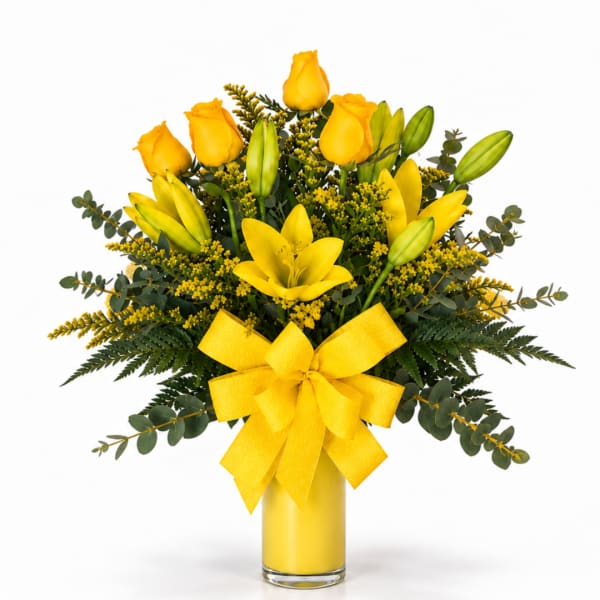 Yellow roses and lilies in a glass vase with a yellow bow