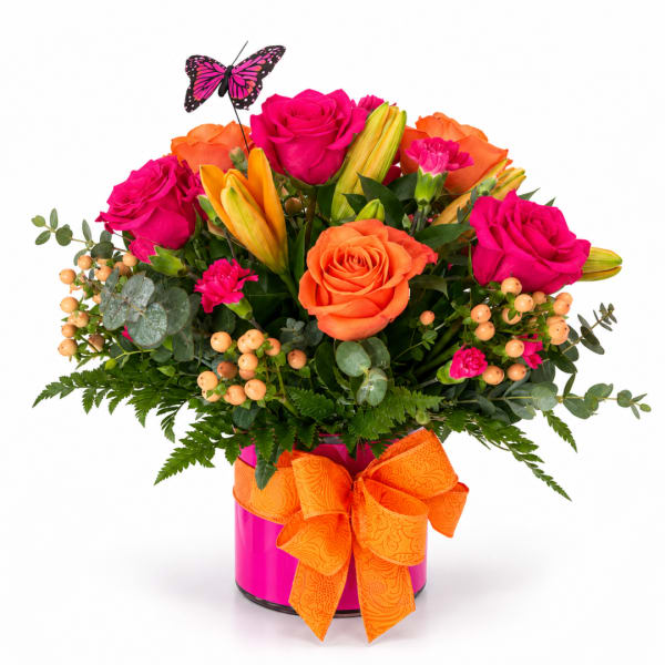Bright bouquet of pink and orange roses in a pink vase with an orange bow