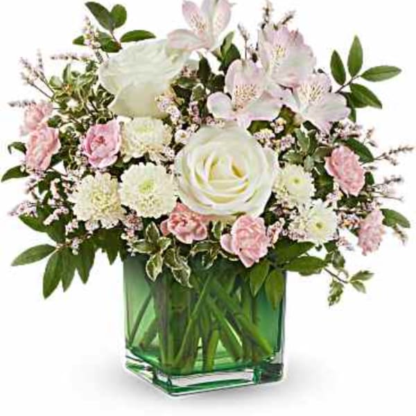 Pink and white flower arrangement in a green glass vase