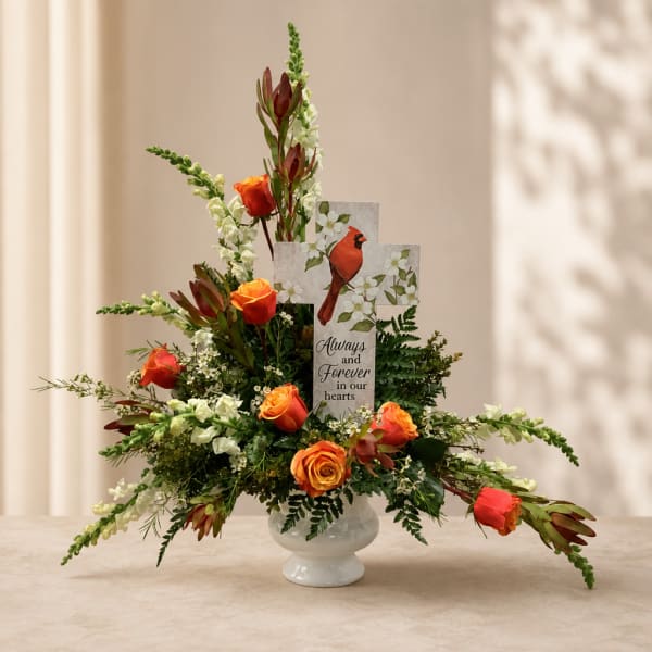 Orange roses in a white vase with a memorial card and cardinal design