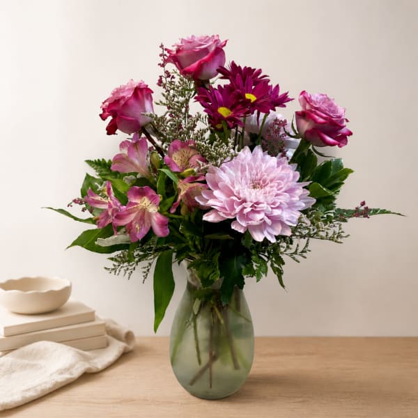 Pink roses and mixed blooms in a glass vase