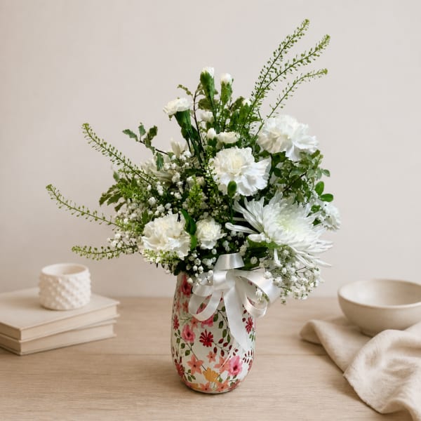 White floral arrangement in a floral vase with a satin ribbon