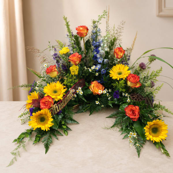 Colorful floral spray with sunflowers and orange roses on a table