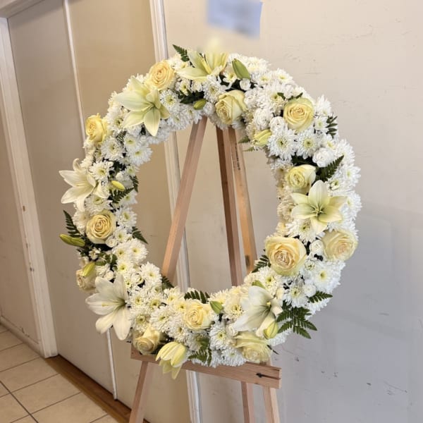 Cream and white floral wreath on a wooden easel