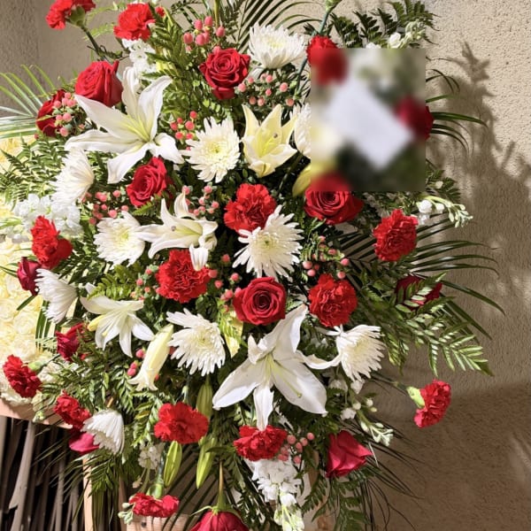 Large red and white funeral spray with roses, lilies, and chrysanthemums