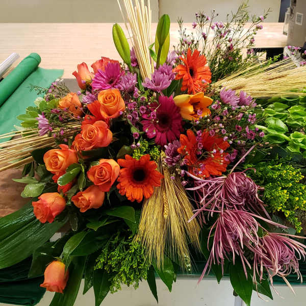 Mixed bouquet with orange roses, gerbera daisies, and purple blooms