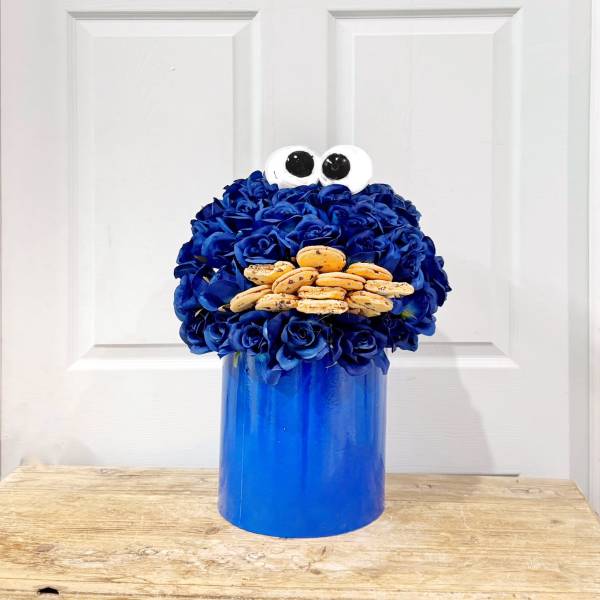 Blue flower arrangement with cookie eyes and a blue container