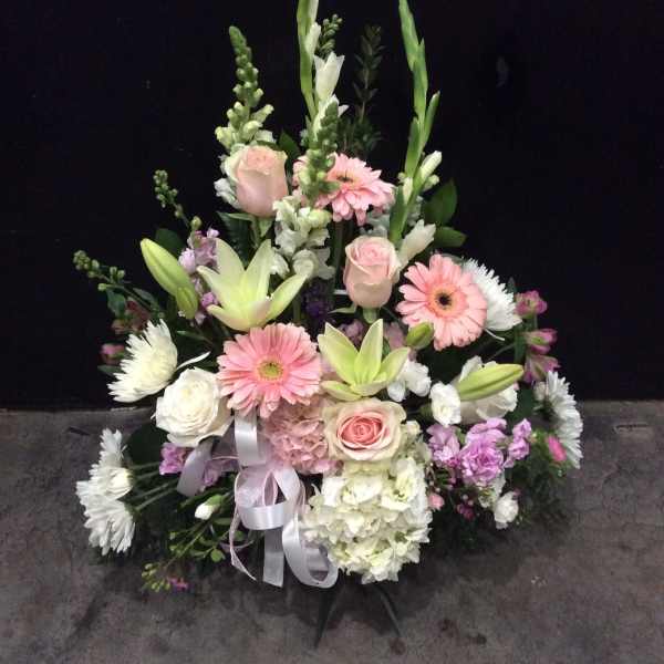 Tall pastel floral arrangement with roses, lilies, and gerbera daisies