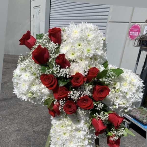 Standing cross arrangement of red roses and white chrysanthemums
