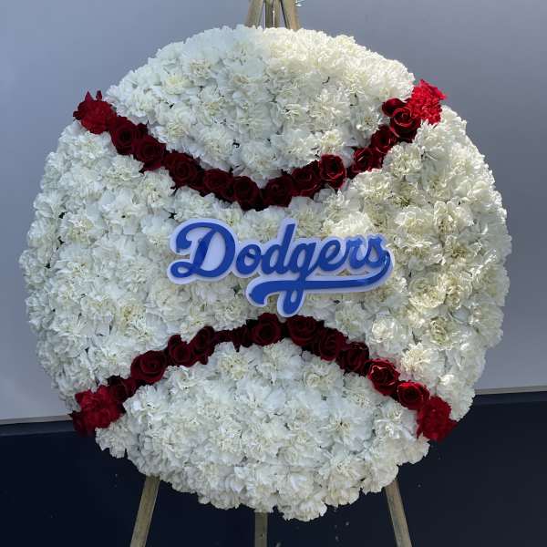 Round floral tribute of white flowers with red rose stripes and a Dodgers sign