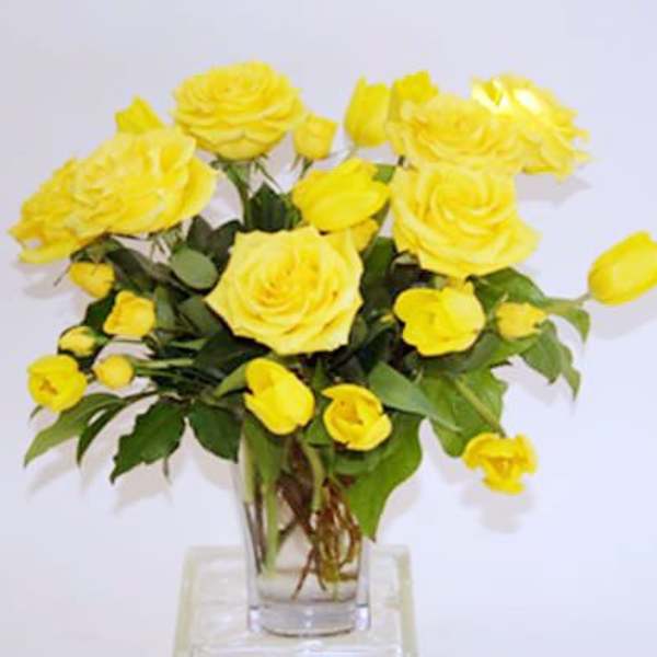Yellow roses arranged in a clear glass vase