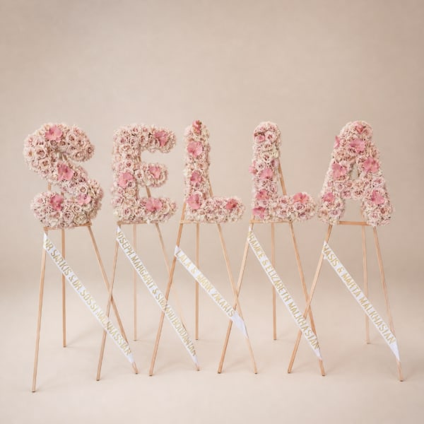 Floral letter stands spelling SELAM in pale pink roses