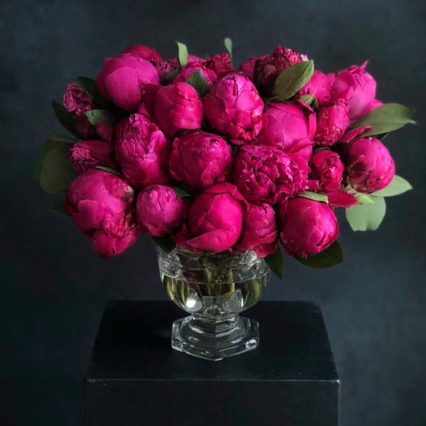 Bright pink peony bouquet in a clear glass vase