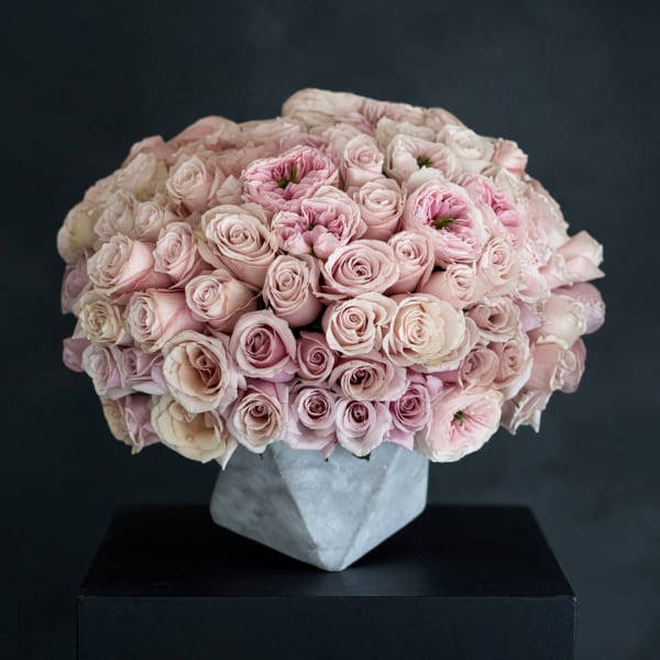 Large bouquet of pale pink roses in a gray geometric vase
