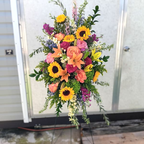Tall mixed bouquet with sunflowers, roses, lilies, and purple accents