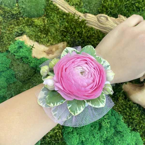 Pink flower wrist corsage with green leaves and tulle
