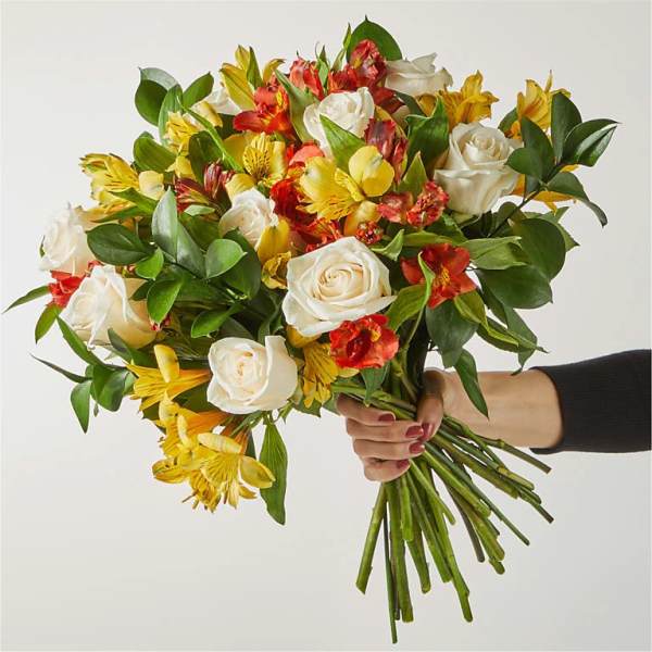 Handheld bouquet of white roses and yellow-red alstroemeria
