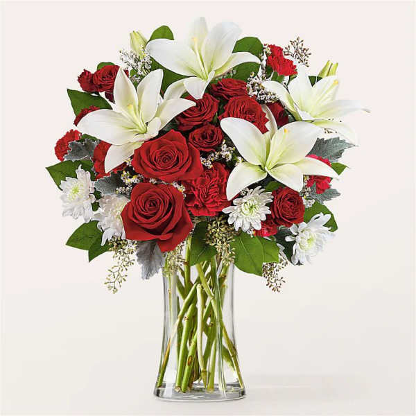 Red roses and white lilies in a clear glass vase