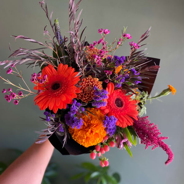 Bright mixed bouquet with gerbera daisies, marigolds, and purple filler flowers