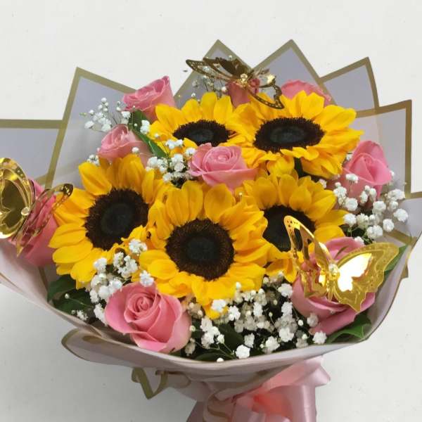 Bouquet of sunflowers and pink roses with white baby's breath and butterfly decorations