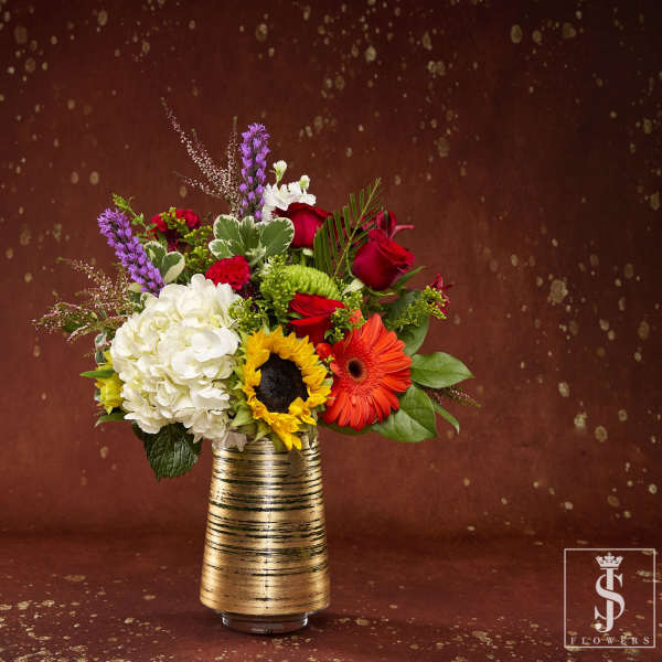 Mixed bouquet in a gold striped vase with red, white, and orange flowers
