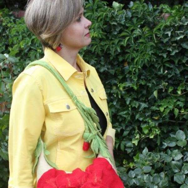 Woman wearing a large red flower-shaped crossbody bag