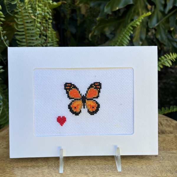 Cross-stitch card with an orange butterfly and small red heart