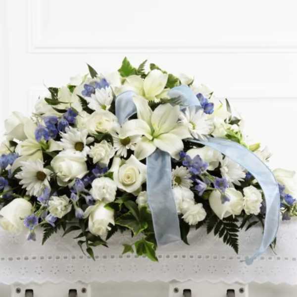 White and blue funeral casket spray with ribbon