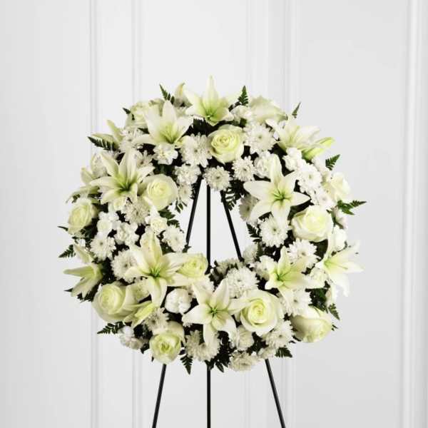 White floral wreath on a black stand