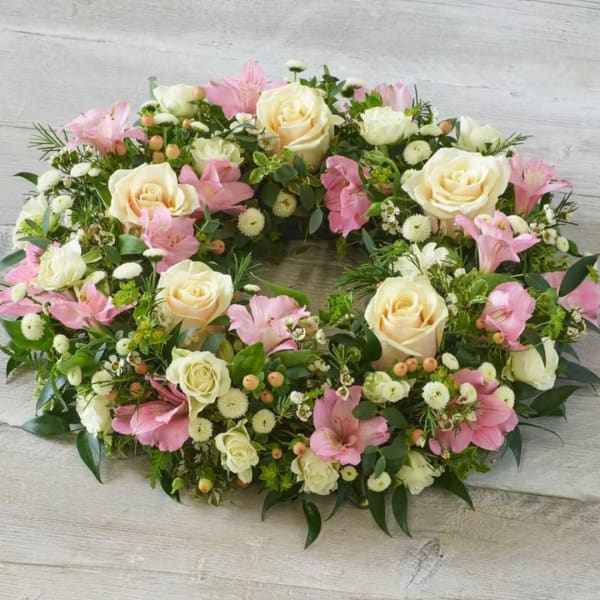 Oval floral wreath with cream roses and pink blooms