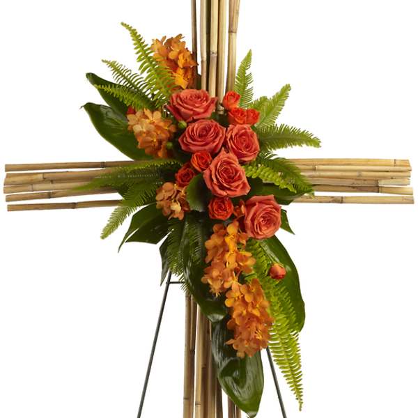 Orange roses and orchids arranged on a bamboo cross stand