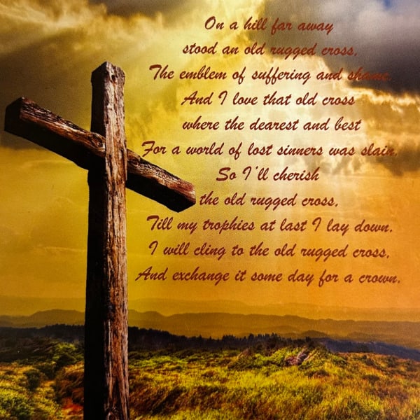 A rustic wooden cross against a golden sky with poem text