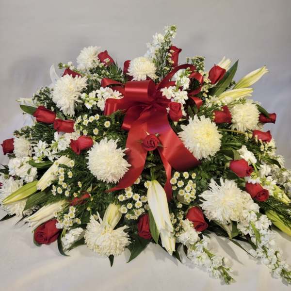 Large red, white, and yellow floral spray with a red ribbon bow