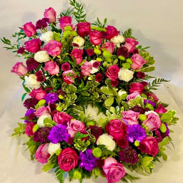 Heart-shaped floral wreath with pink, white, purple, and green blooms