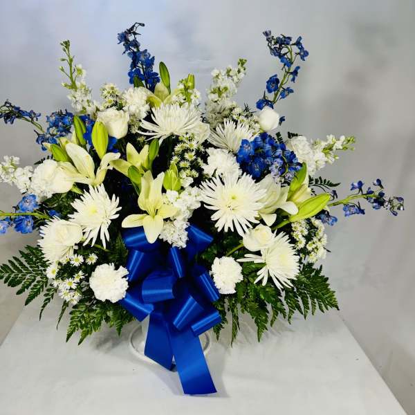 White and blue floral arrangement with a large blue ribbon