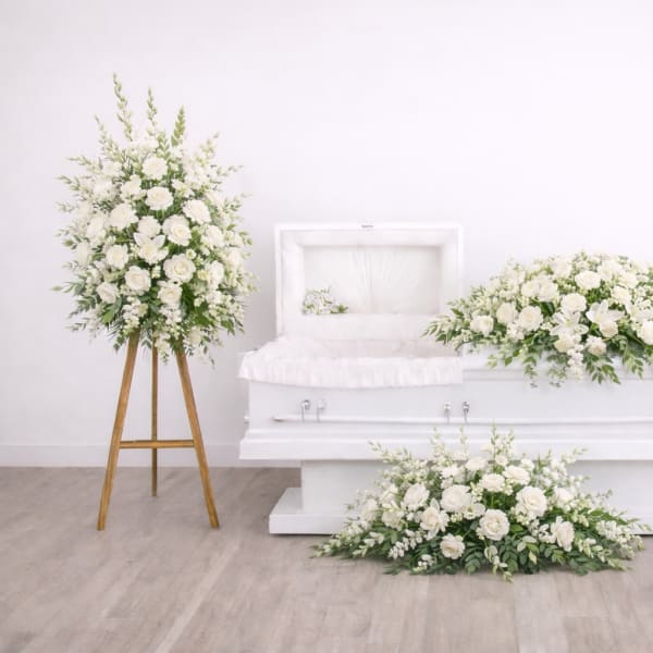 White floral funeral casket spray with matching standing arrangement