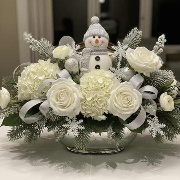 White roses and hydrangeas arranged with a small snowman figurine in a bowl.
