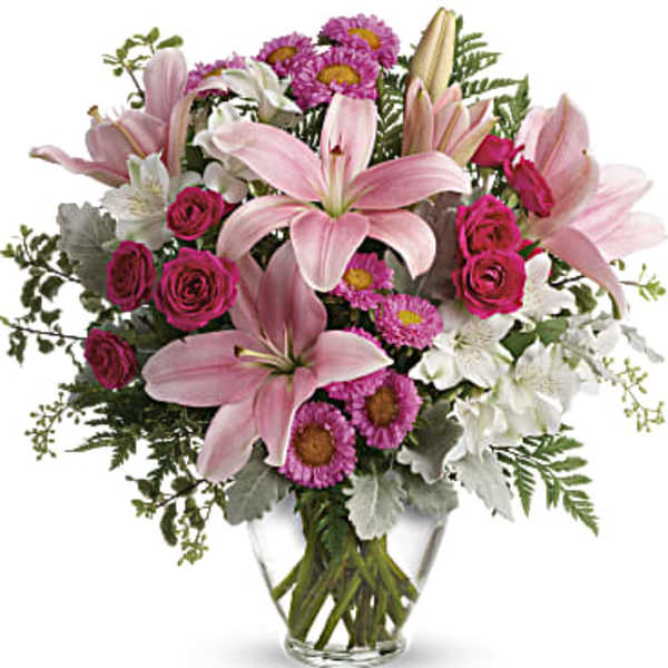 Pink lilies and roses in a clear glass vase