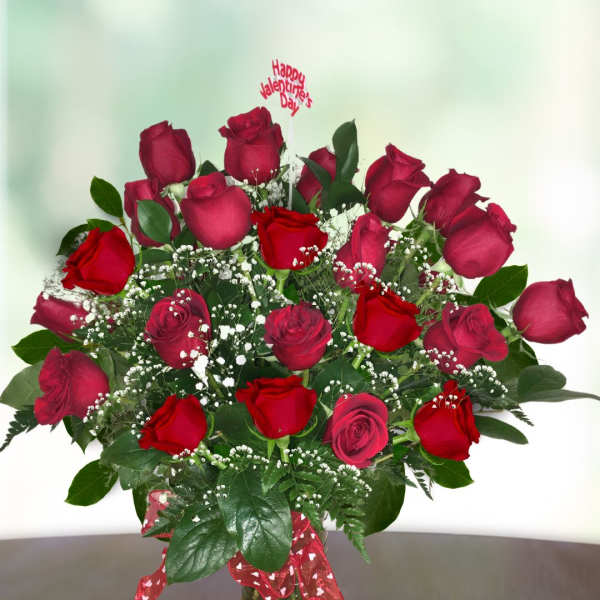 Bouquet of red roses in a glass vase with a Valentine topper
