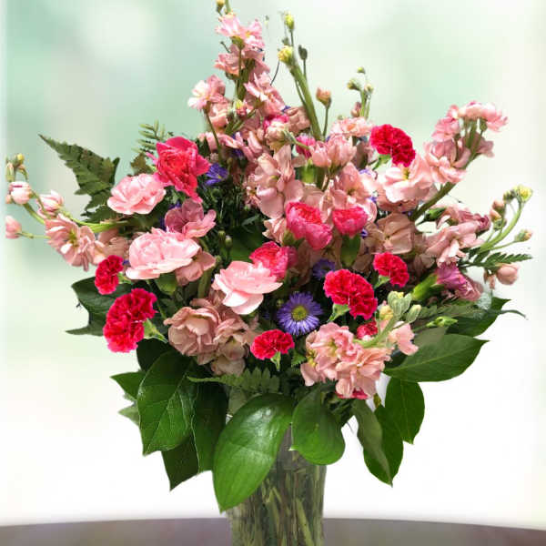 Pink and red mixed bouquet in a clear glass vase
