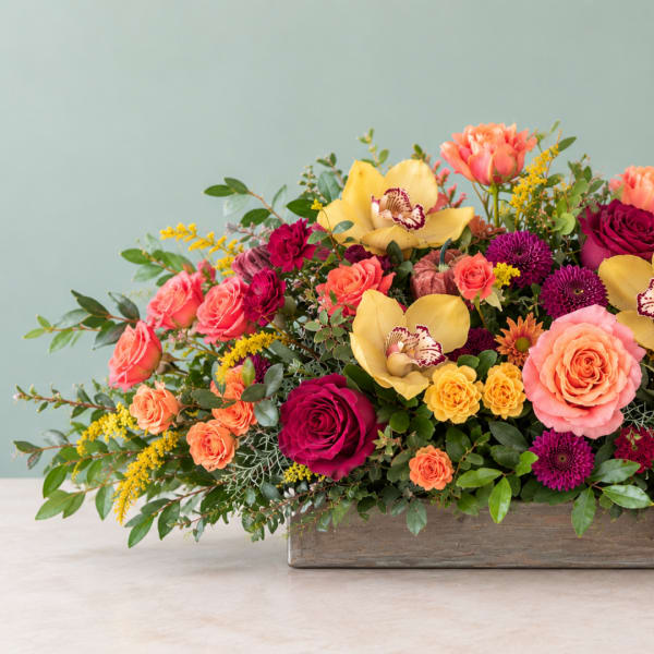 Colorful mixed flower arrangement in a wooden container