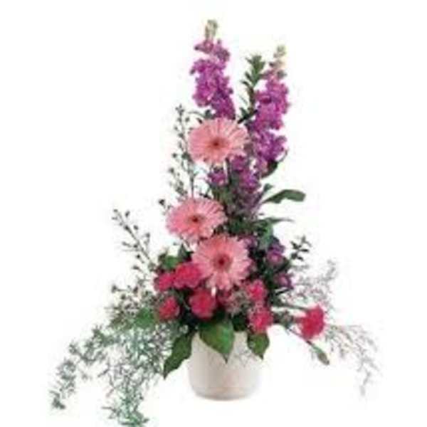 Tall pink and purple floral arrangement in a white vase
